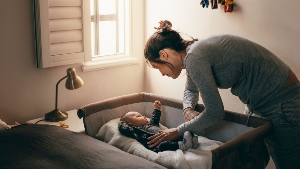 mãe colocando o bebe para dormir 